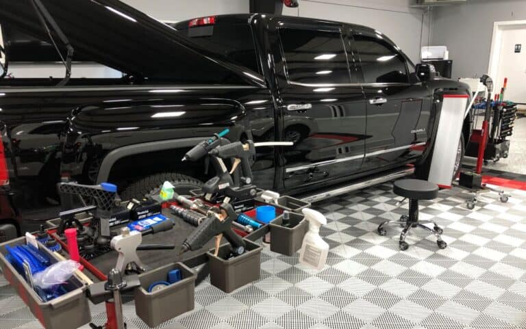 Black pickup in the shop for door ding and dent repair