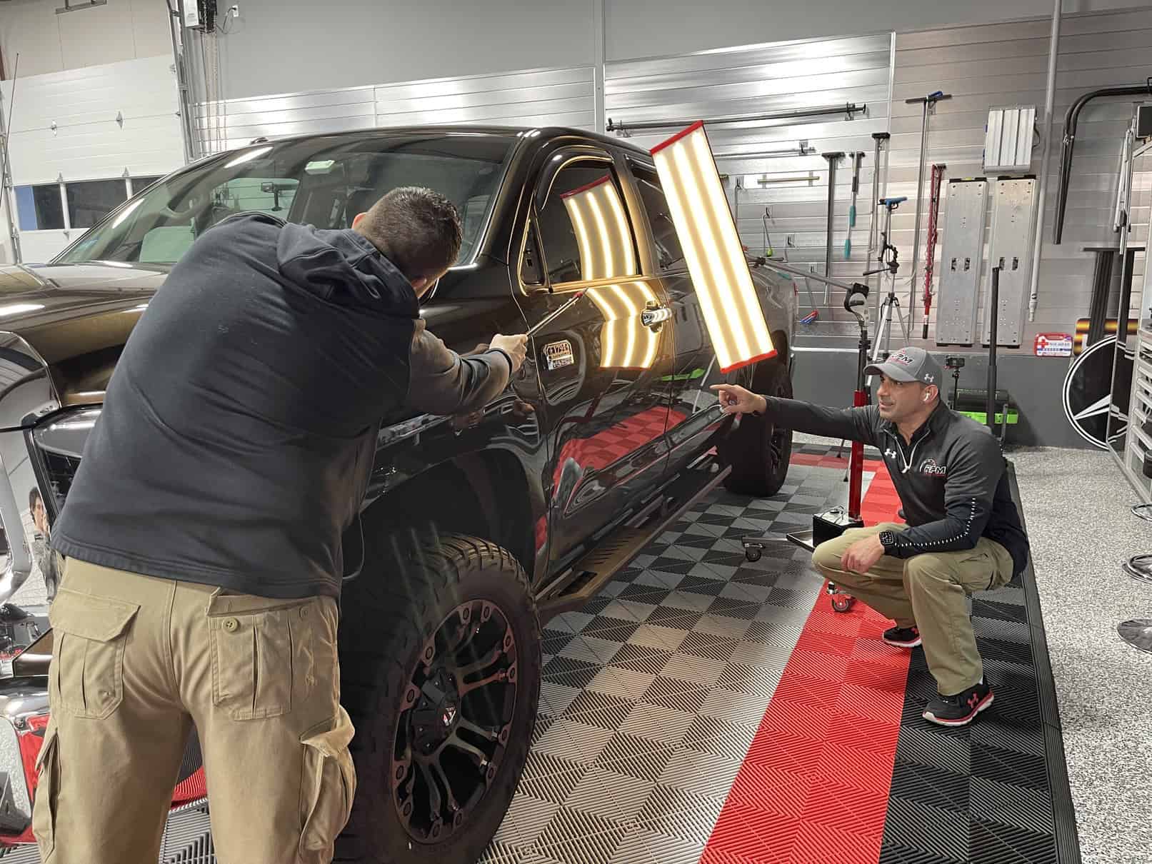 PDR training session at RPM Dent Repair - student learning hands-on paintless dent repair techniques under instructor supervision at our licensed Massachusetts shop facility