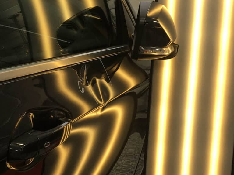 Black Vehicle Door Panel Dent Assessment — PDR Raynham MA PDR light board reflected across a black vehicle door panel revealing a crease dent at RPM Dent Repair Raynham Massachusetts