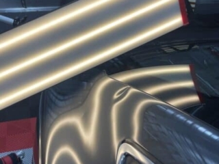 Large crease dent running across the rear quarter panel of a dark vehicle before paintless dent repair in Raynham MA