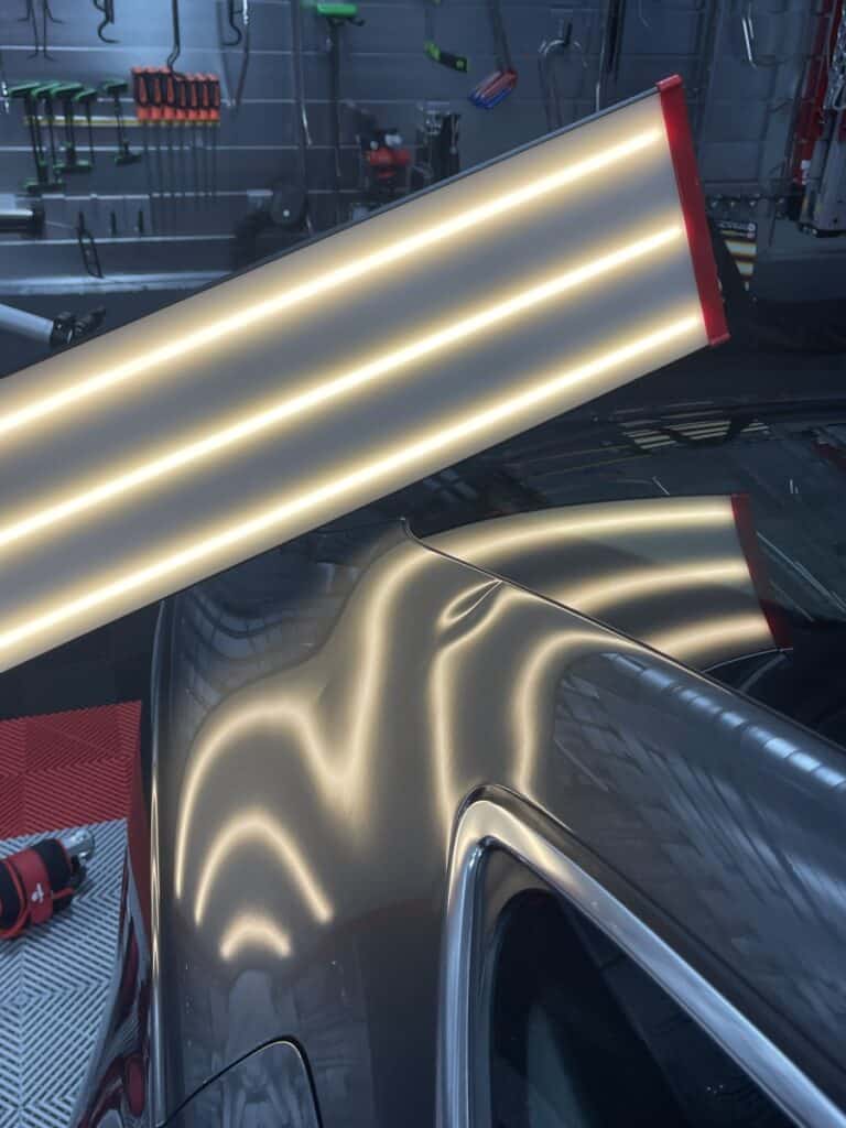 Crease Dent on a Rear Quarter Panel — PDR Raynham MA Large crease dent running across the rear quarter panel of a dark vehicle under PDR light in Raynham MA