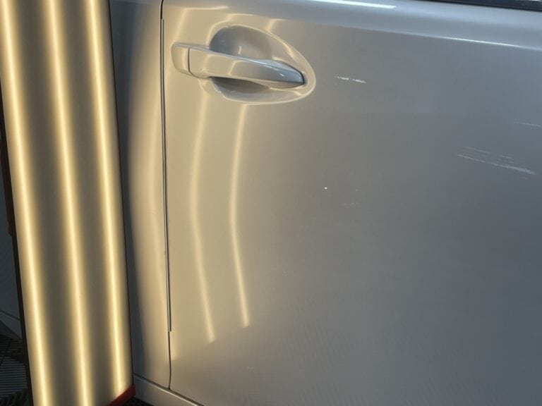 Long crease dent running across vehicle body panel before paintless dent repair in Raynham MA