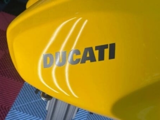Ducati motorcycle fuel tank fully restored after paintless dent repair &mdash; no paint